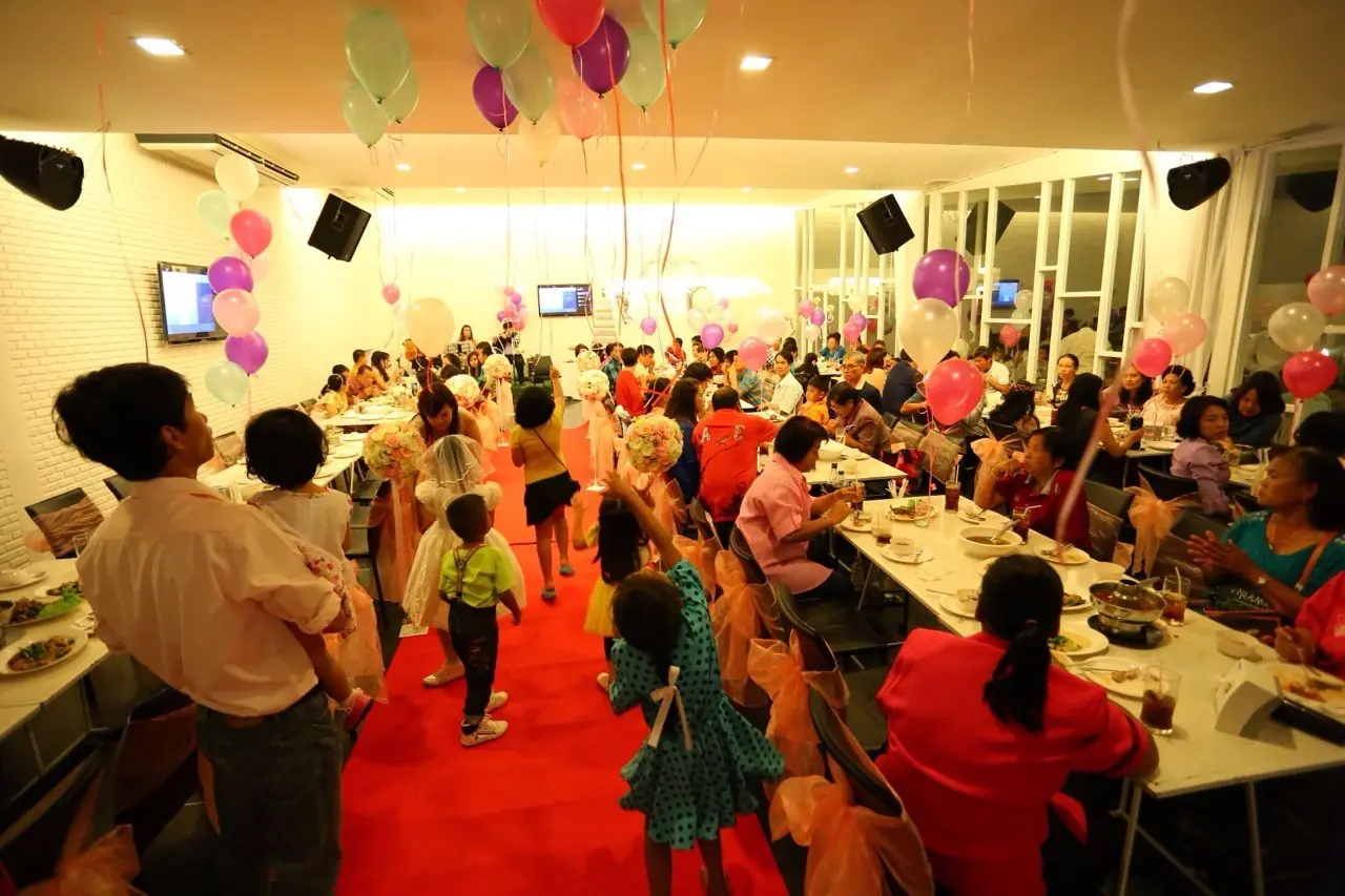 งานเลี้ยงฉลองในห้องจัดเลี้ยง บอลลูนสีสันสดใส ต้นทองหลาง